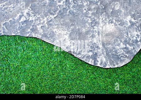 The rough surface texture of gray color concrete pathway brick and green color of plastic artificial grass Stock Photo