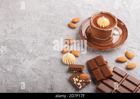 Cup of hot chocolate and pieces of milk chocolate with almonds on a gray concrete background. side view, copy space. Stock Photo