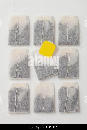 Black tea in teabags with yellow label on white background. Top view Stock Photo