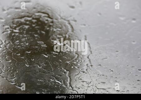 from the inside of a car  looking out of the windscreen that is covered in raindrops Stock Photo