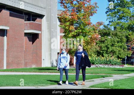 Holland, Michigan, USA. Pair of students walking on the campus at Hope College in the fall following the COVID-19 pandemic in the United States. Stock Photo