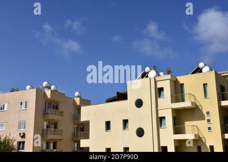 Apartment buildings with solar thermal heating hot water storage on the roof, Cyprus Stock Photo