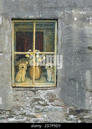 Outside view of window in cottage with picture of china dogs and vase of flowers behind, Bressay, Shetland Stock Photo