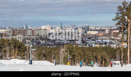 Yekaterinburg, Russia - February 26, 2019. The training ski slope of the sports complex on Uktus Mountain over the background a pine forest and a pano Stock Photo