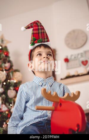 Cute kid on Moose toy with holiday decorations Stock Photo