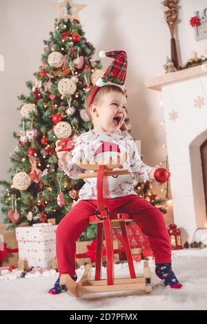 Cute little boy on Reindeer toy celebrate Christmas holidays on his way Stock Photo