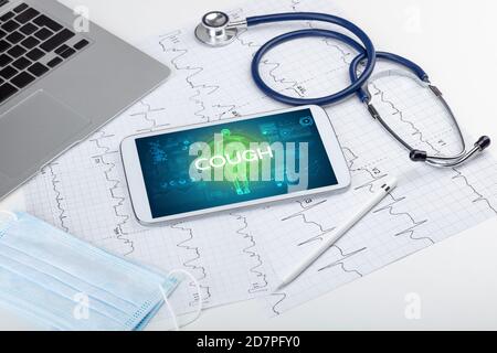 Tablet pc and doctor tools with COUGH inscription, coronavirus concept Stock Photo