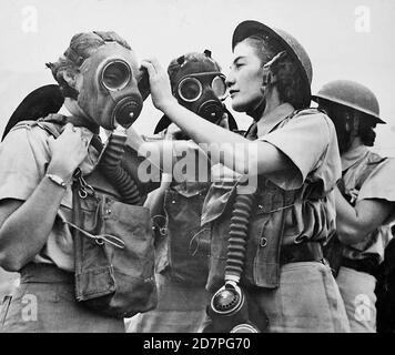 South Africa History:  South African women's services on duty in the Middle East: A South African W.A.A.F. Sergeant instructor fitting a gas mask to a beginner ca. 1942 Stock Photo