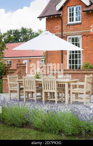 Large UK house with garden furniture in a back garden with patio terrace Stock Photo