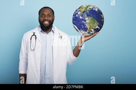 Doctor shows the world cleaned of covid19 virus and now safe. earth provided by Nasa Stock Photo