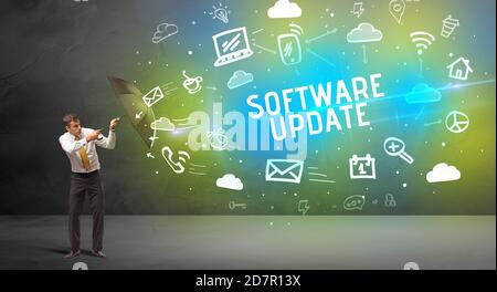 Businessman defending with umbrella from SOFTWARE UPDATE inscription, modern technology concept Stock Photo