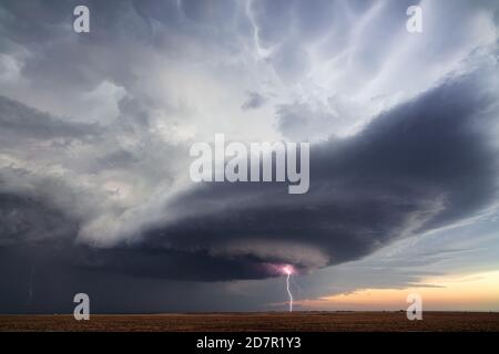 Supercell thunderstorm and cloud to ground lightning strike near Sublette, Kansas Stock Photo