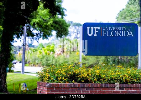 Gainesville, USA - April 27, 2018: Sign for entrance to campus of UF University of Florida in central state with nobody and flower decorations Stock Photo