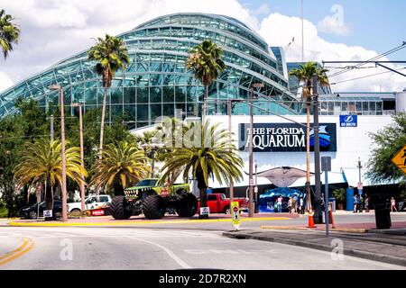 Tampa, USA - April 27, 2018: Downtown city in Florida and sign on modern building exterior for aquarium with street road and palm trees Stock Photo
