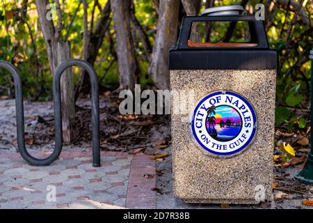 Naples, USA - April 30, 2018: Florida coast gulf of Mexico with closeup of sign for city text downtown on garbage trash bin can Stock Photo