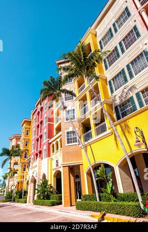 Naples, USA - April 30, 2018: Bayfront condo apartment condominium building with palm trees in community shopping center blue sky multicolored vibrant Stock Photo