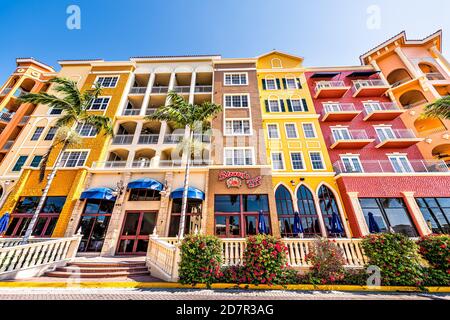 Naples, USA - April 30, 2018: Bayfront condo apartment wide angle view of building with palm trees in community shopping center blue sky multicolored Stock Photo