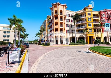 Naples, USA - April 30, 2018: Bayfront apartment building with palm trees in community shopping center with restaurants and blue sky multicolored vibr Stock Photo