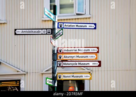 Akureyri, Iceland - June 17, 2018: Street road in town village city with closeup of intersection directional sign for famous museums and stores shops Stock Photo