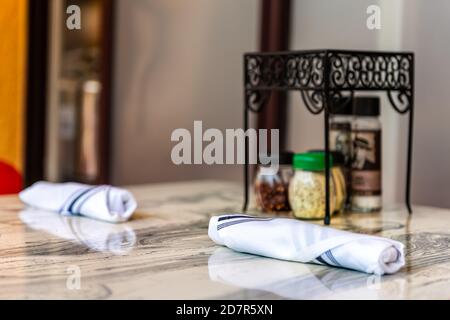 Closeup of two folded napkins with utensils on restaurant table cafe outside with condiments and nobody Stock Photo