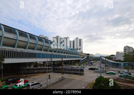 Tin Shui Wai Station of the Mass Transit Railway (MTR) system in Hong Kong with a light rail vehicle running on Tin Yiu Road below Stock Photo