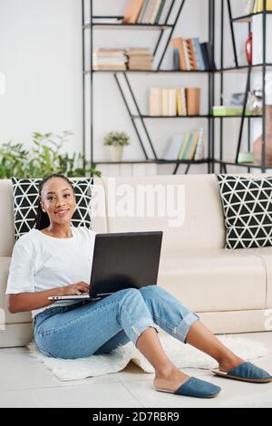 Female coder sitting on the floor Stock Photo