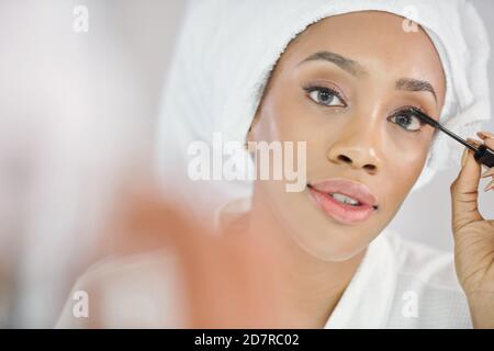 Woman applying volumizing mascara Stock Photo