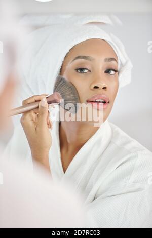 Woman applying make-up Stock Photo