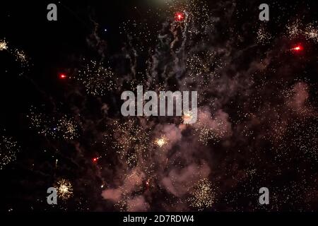 On a black background, ash spots and rays of fireworks with smoke. Festive dark background. Stock Photo