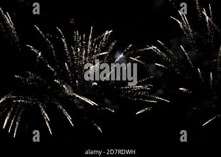 On a black background, rays and sparks of scattering fireworks. Stock Photo