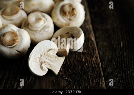 Fresh champignon mushrooms on wooden table, closeup. Space for text Stock Photo