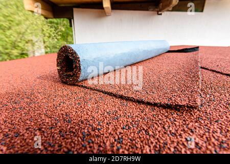 Red flexible roll tile on the roof of the house Stock Photo
