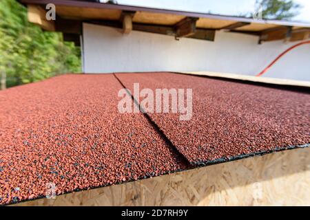 The roof of a small house is covered with a roof - soft bitumen roll tiles Stock Photo