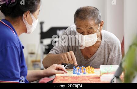 Beijing, China. 6th Aug, 2020. A senior resident(R) plays chess with a staff member at a nursing home in Beijing, capital of China, Aug. 6, 2020. Credit: Li Xin/Xinhua/Alamy Live News Stock Photo