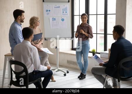 Indian female coach make flip chart presentation for employees Stock Photo