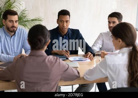 International businesspeople negotiate at meeting in office Stock Photo