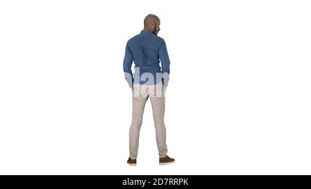 Arab in casual looking around with hands in pockets on white background. Stock Photo