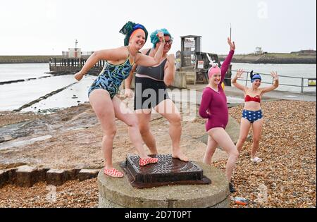 Brighton UK 25th October 2020 - Members of the 'Salty Seabirds' wild swimming group from Brighton & Hove prepare to take part in World Swim Hat Day near the entrance of Shoreham harbour this morning despite the dreadful weather : Credit Simon Dack / Alamy Live News Stock Photo