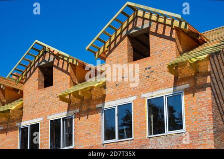 Unfinished house of brick, still under construction before installing the roof. Stock Photo