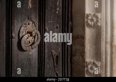 Antique church door handle and key lock with section of stone carved door frame surround Stock Photo