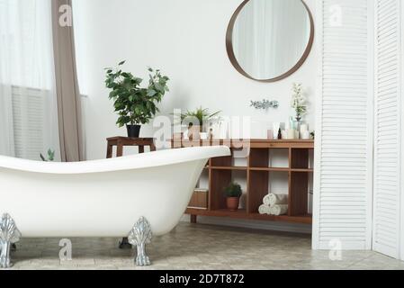 Modern stylish bathroom without anyone. Front view of white modern bath in contemporary apartment with stylish loft interior design, house decor. Stock Photo