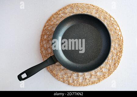 Frying pan on woven napkin, flat lay kitchenware Stock Photo