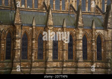 Lincoln Cathedral alternate viewpoint between trees, Northgate outside Lincoln Hotel. Lord Alfred Tennyson statue in garden. Famous Yellowbelly, Stock Photo