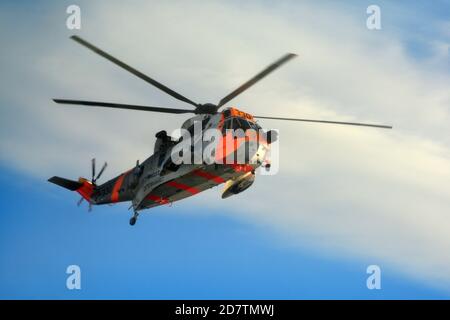 Search and Rescue Sea King helicopter of the Royal Norwegian Air Force seen hovering over a ship at sea Stock Photo