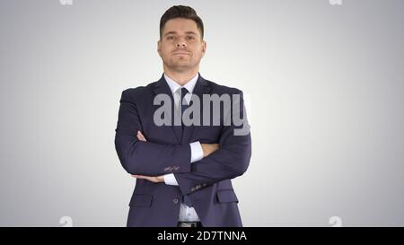 Businessman with fo;ded hands looking to camera on gradient back Stock Photo