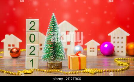 Wooden blocks 2021, Christmas tree, miniature houses and gifts. New Year or Xmas winter holiday. Decoration, celebration. The concept of the beginning Stock Photo