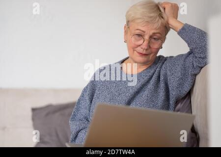 Mature woman working with laptop at home Stock Photo