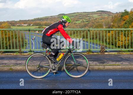 Chorley CC Male cyclist riding Cube Attain sports road bike on countryside route crossing motorway bridge in rural Lancashire, UK Stock Photo