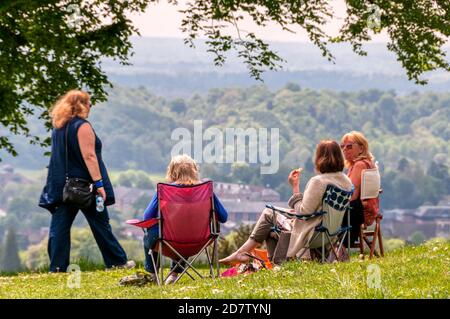 A goup of friends sitting and enjoying the view on Reigate Hill, Surrey, in London's green belt. Stock Photo