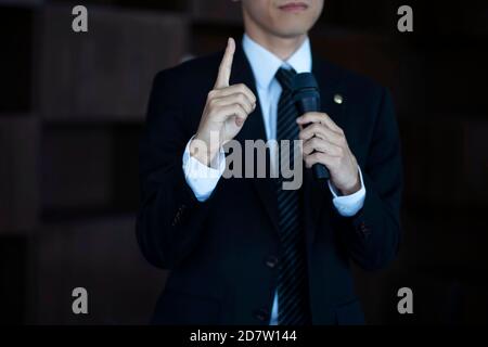 Cropped image of businessman giving presentation with microphone Stock Photo